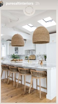 a kitchen with two hanging lights above the island