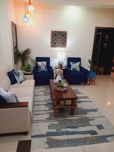 a living room with couches, tables and lamps on the wall in front of it