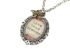 This necklace is a lovely gift idea and an encouraging statement. The necklace pendant consists of a setting made of antique silver-colored metal and a hand-crafted glass cabochon with the saying "Live Your Dreams". A butterfly charm is attached to the top of the setting. The necklace pendant measures 4 L x 2.8 W cm. The chain is 45 cm long. A different chain length is no problem and at no extra cost. Antique Silver Pendant Necklace For Gift, Silver Inspirational Necklace For Her, Vintage Silver Charm Necklaces As Gifts, Inspirational Silver Necklace Gift For Her, Silver Vintage Charm Necklaces For Gifts, Inspirational Silver Necklace For Her, Antique Silver Adjustable Necklace As A Gift, Silver Vintage Charm Necklace For Mother's Day, Mother's Day Silver Necklace With Vintage Charm