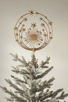 a christmas tree with ornaments hanging from it's branches and a star decoration on top