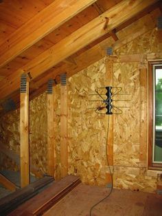 an unfinished room with wooden walls and wood beams on the wall is being worked on