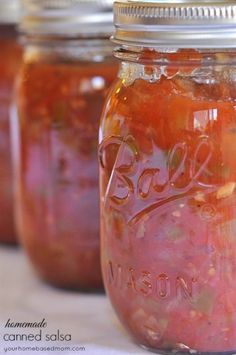 four jars filled with food sitting on top of a table