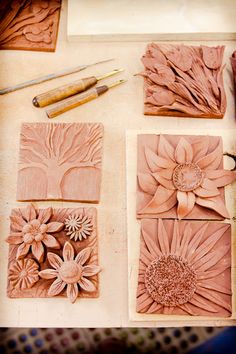 some flowers are being carved into small tiles on a table with paintbrushes and glue