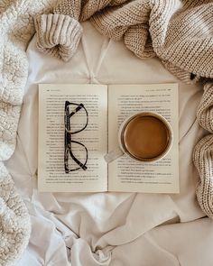 an open book with glasses and a cup of coffee