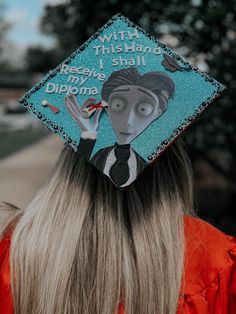 a woman wearing a blue graduation cap that says, with this hand i shall being diploma