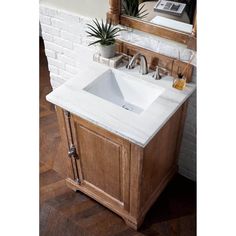 a white sink sitting under a mirror next to a wooden cabinet