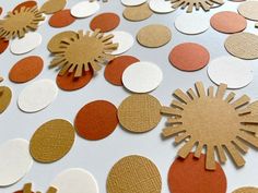 an assortment of paper circles and shapes on a white tablecloth with orange, gold, and white dots