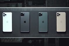 four iphones are lined up in a row, all different colors and sizes on display