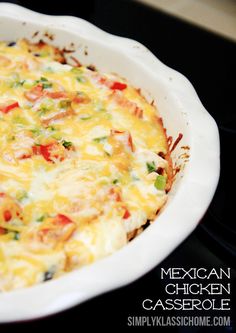 a casserole dish with tomatoes, cheese and other toppings in a white baking dish