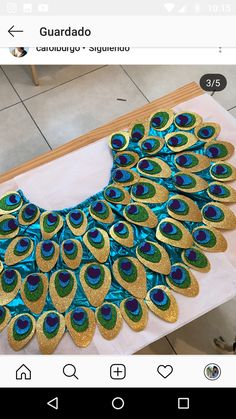 an image of a peacock made out of gold and blue glitters on a table