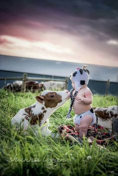 a baby in diapers playing with a cow