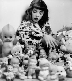 black and white photograph of a woman surrounded by stuffed animals