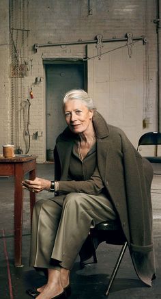 an older woman sitting in a chair next to a desk