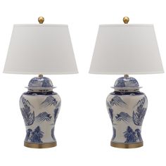 two blue and white vases with lamps on them