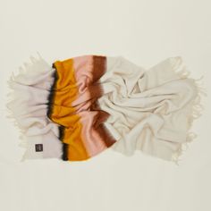 two scarves laying side by side on top of each other, one orange and the other white