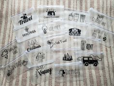 several clear bags with different logos on them sitting on a tablecloth covered surface in front of a striped background