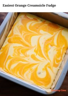 an orange creamsice fudge in a pan on a wooden table with text overlay