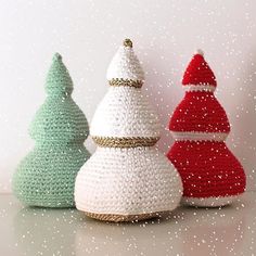 three crocheted christmas trees sitting next to each other