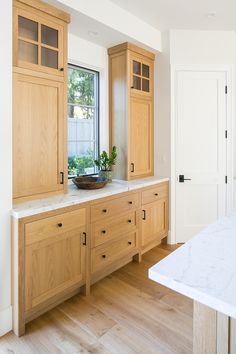 a kitchen with wooden cabinets and marble counter tops