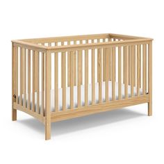 a small wooden crib with white sheets on the bottom and side rails, in front of a white background