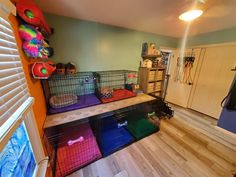 a room filled with lots of caged animals on top of wooden flooring next to a window