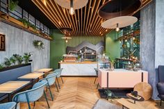 the interior of a restaurant with tables, chairs and plants on the wall above them