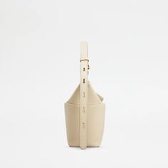 Elevate your style with the T-Box Mini Bag in Beige. Inspired by Japanese origami, this boxy bag features a T Timeless turn-lock buckle and adjustable handle. Crafted in soft calfskin leather, it adds a contemporary touch to any outfit. A must-have for fashion-forward individuals. Leather Bucket Bag With Magnetic Closure And Double Handle, Timeless Soft Leather Bucket Bag, Modern Cream Box Bag With Removable Pouch, Modern Cream Box Bag With Detachable Handle, Modern Rectangular Bucket Bag With Magnetic Closure, Modern Leather Bucket Box Bag, Modern Beige Soft Leather Bucket Bag, Modern Bucket Bag With Magnetic Closure And Top Handle, Modern Top Handle Bucket Bag With Magnetic Closure