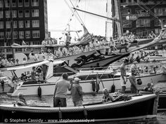 black and white photograph of people on boats in the water