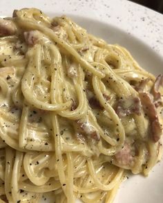 a white plate topped with pasta covered in sauce