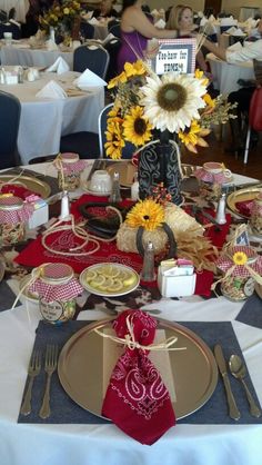 the table is set with sunflowers and silverware for an elegant dinner party