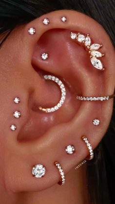 a woman wearing ear piercings with diamonds on the inside of her ears and behind her ear