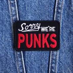 a patch that says sorry we're punks on the back of a jean jacket