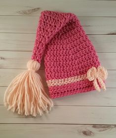 a pink crocheted hat with a tassel