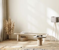 a living room with a rug, table and lamp on the floor in front of a window