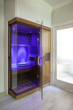 a room with a purple light inside of it and a laptop on the desk in the corner