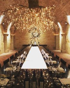 a long table is set up with wine glasses and place settings for people to eat