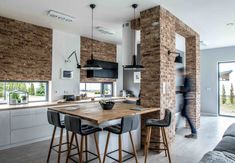 a kitchen with an island and bar stools in front of the counter top that is made out of bricks