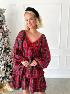 Get into the holiday spirit with our Christmas Magic Red Plaid Tiered Dress. With a red plaid tiered skirt, long sleeves, and festive red and green ricrac trim, this dress is the perfect addition to your holiday wardrobe. Spread some holiday cheer in style! Green and red ricrac trim Tiered ruffled skirt Long sleeves V-neckline Smocked back 100% Polyester SIZE AND FIT:Fits TTS. If you are between sizes and not bustier, you could size down! A great length! Geordian is in a small. Sarah is in a lar Pink And Red Christmas Outfit, Christmas Vintage Outfit, Christmas Tea Party Outfit, Plaid Christmas Holiday Dress, Plaid Dress For Christmas Holiday, Festive Holiday Dress With Ruffles And Long Sleeves, Winter Plaid Ruffled Dresses, Festive Long Sleeve Holiday Dress With Ruffles, Red Holiday Dress With Ruffle Hem