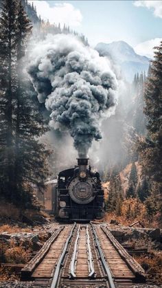 an old steam engine train traveling down the tracks