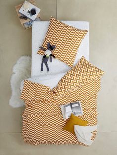 an overhead view of a bed with yellow and white sheets, pillow cases and pillows