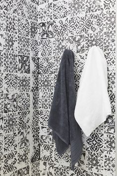 two towels hanging on the wall next to each other