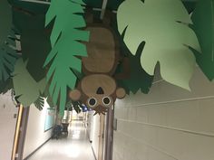 there is a paper cut out of a bear hanging from the ceiling in this hallway