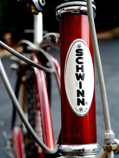 a close up view of the handlebars on a red and silver bicycle with an crown sticker