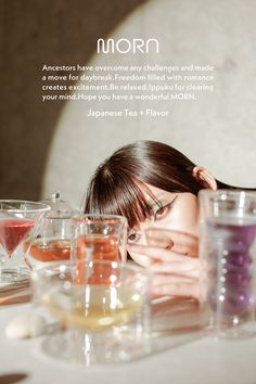 a woman is sitting at a table with many glasses on it and the words morn above her