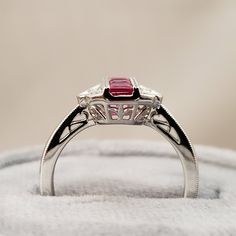 "July Birthstone! Bright Red Ruby Ring featuring 3 square Channel Set Genuine Ruby center stones (Ruby weight equalling .57ct) in a delicate vintage inspired filigree design full of Genuine White Diamonds, (Diamond weight equals .06 carats total) A Unique 14kt White Gold Ring, with Solid white gold bars known as a channel on the rubies & prongs on the diamonds add a bright finish while holding the stone firmly in place. This Ruby ring is perfect for everyday ware. **Ring size: 6.5 **Ruby is Luxury Sterling Silver Ruby Ring With Brilliant Cut, Antique Ruby Diamond Ring Hallmarked, Elegant Red Diamond-cut Ruby Ring, Silver Diamond-cut Ruby Ring For A Gift, Vintage Silver Ruby Ring, Hallmarked, Rings Ruby, Star Ruby Ring, Diamond Ring Vintage, Ruby Diamond Ring