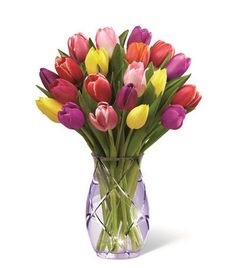 a vase filled with lots of colorful tulips