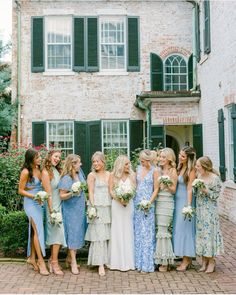 a group of women standing next to each other in front of a building