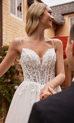 a woman in a white dress standing next to a man