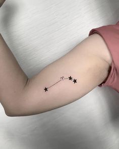 a woman's arm with a small star tattoo on the left side of her arm