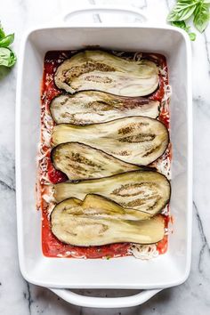 eggplant stuffed with parmesan cheese and sauce in a white casserole dish